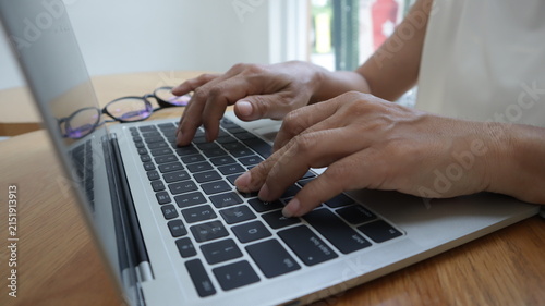 Professional business and financial planning concept featuring an entrepreneur working with a laptop, calculator, smartphone, and digital tablet at a wooden desk