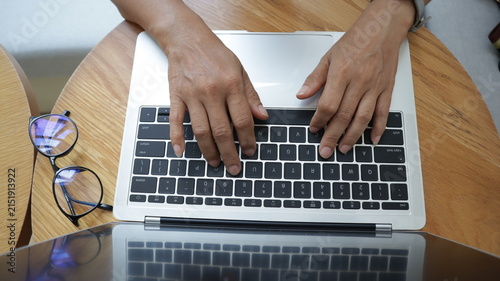 Professional business and financial planning concept featuring an entrepreneur working with a laptop, calculator, smartphone, and digital tablet at a wooden desk