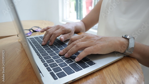 Professional business and financial planning concept featuring an entrepreneur working with a laptop, calculator, smartphone, and digital tablet at a wooden desk