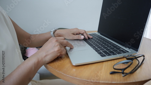 Professional business and financial planning concept featuring an entrepreneur working with a laptop, calculator, smartphone, and digital tablet at a wooden desk