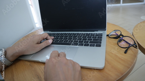Professional business and financial planning concept featuring an entrepreneur working with a laptop, calculator, smartphone, and digital tablet at a wooden desk