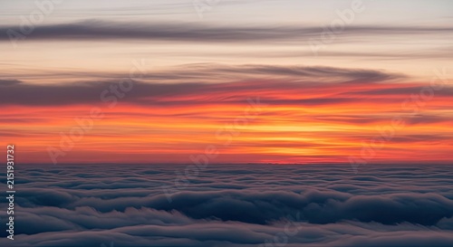 Vibrant Sunset Over a Sea of Clouds with Fiery Orange and Red Hues.