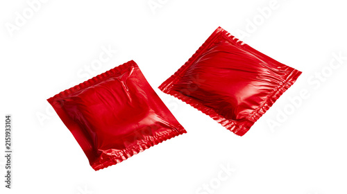 Two red foil packets of sauce or condiment