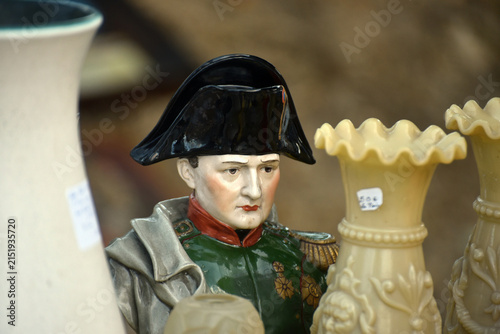 Bust statue of Napoleon displayed among various vintage objects at a flea market, illustrating French history, antique collecting and second hand market culture.
