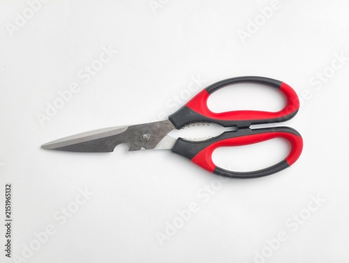 Top view of stainless steel kitchen shears featuring built-in bottle opener and red and black ergonomic handles, isolated on a white background.