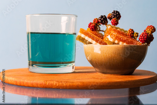 Fotografie Close up of a bowl with jelly candies and blue tea (butterfly pea flower tea)