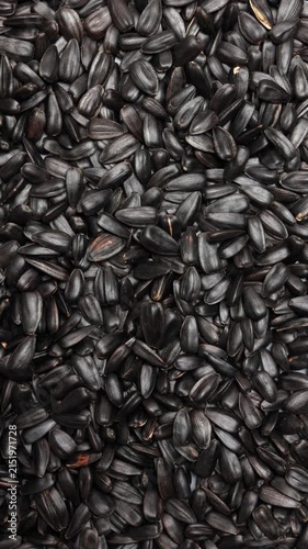 Macro panning shot of black organic sunflower seeds. Vertical