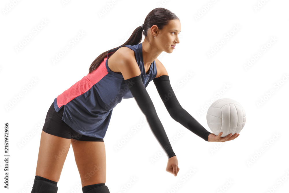 Fototapeta premium Young female atlete serving a volleyball