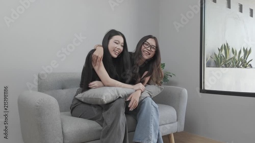 Two Asian Women Having a Fun Conversation Together on a Sofa