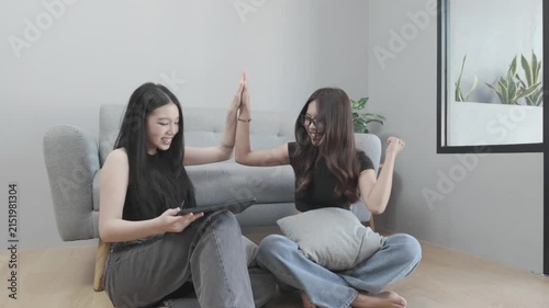 Happy Asian Women Celebrating While Looking at a Tablet