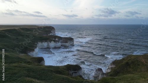 Drone aerial push forward shot of dramatic white chalk cliffs and ocean waves Yorkshire