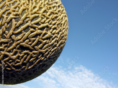           conceptual image of muskmelon  on the blue sky background( like the planet in the universe)    