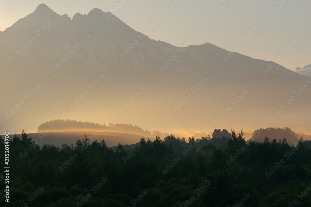 Naklejka premium lomnicky stit mountain peak in slovakia high tatras landscape view sunset misty glow nature rocky summit concept of travel, tourism, nature