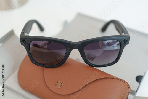 Black smart glasses resting on the protective carrying case