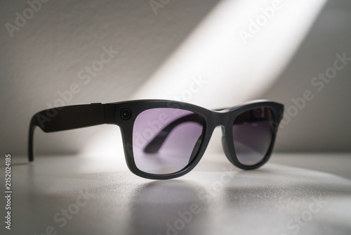 Black smart sunglasses displayed on white background