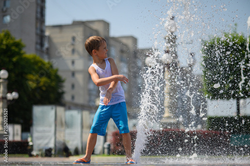 Happy Little Boys Playing in Splash Fountain on Hot Summer Day in City Park