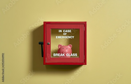 Red emergency box on wall with piggy bank, 