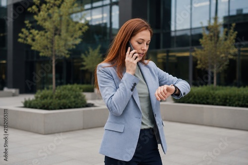 Professional young businesswoman walking in a modern office environment.