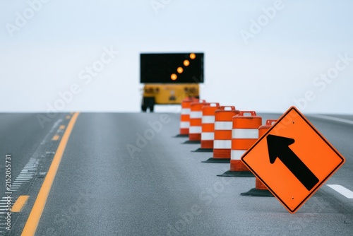 Roadwork ahead Orange traffic cones and signs guide detour on empty highway