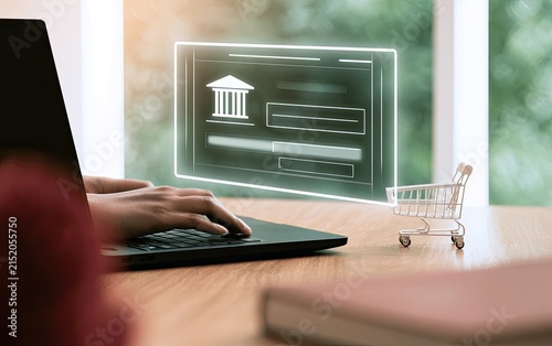 Person using laptop with digital bank interface and tiny shopping cart