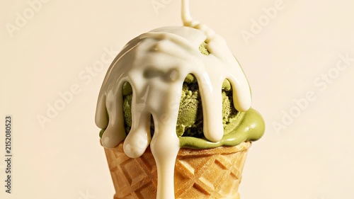 Macro slow motion pouring white chocolate sauce on matcha ice cream
