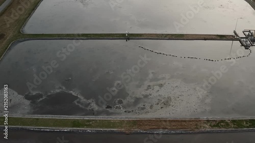 Wastewater treatment basin with polluted sewage, water pollution and industrial environmental contamination, aerial view.