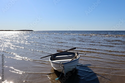 peaceful summer morning at the beach with a lonely boat by the water