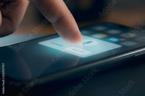 Finger touching allow button on smartphone screen