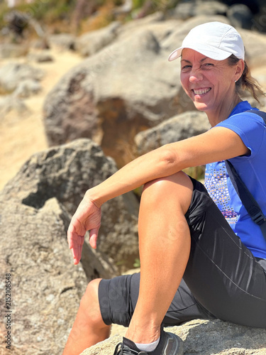 Woman  50 + sitting on mountain rocks