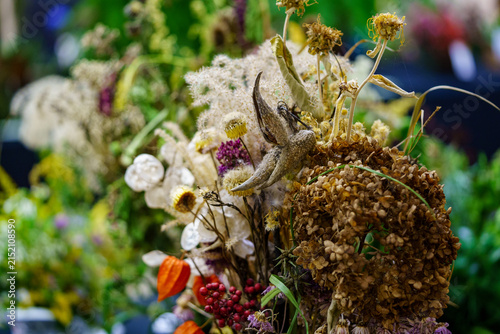 Dried flowers arranged for display at a market during the evening hours