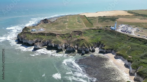 Wide aerial push in view of Flamborough Head Lighthouse and dramatic cliffs, England