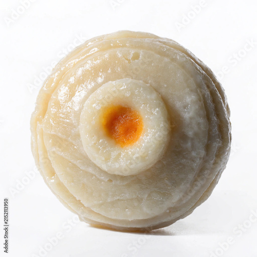 Close-up of a single textured white and orange confectionery or pastry with concentric circles isolated on a white background