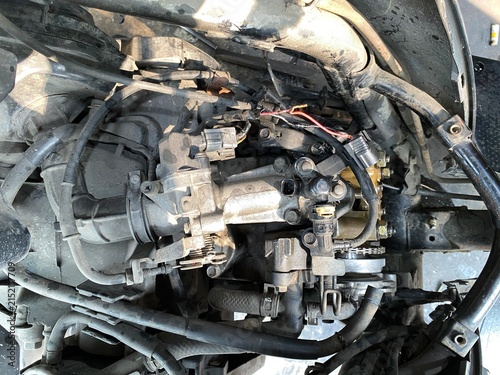 Cuadro en lienzo A close-up photo of an exposed motorcycle engine, revealing cables, hoses, fuel system components, and mechanical parts