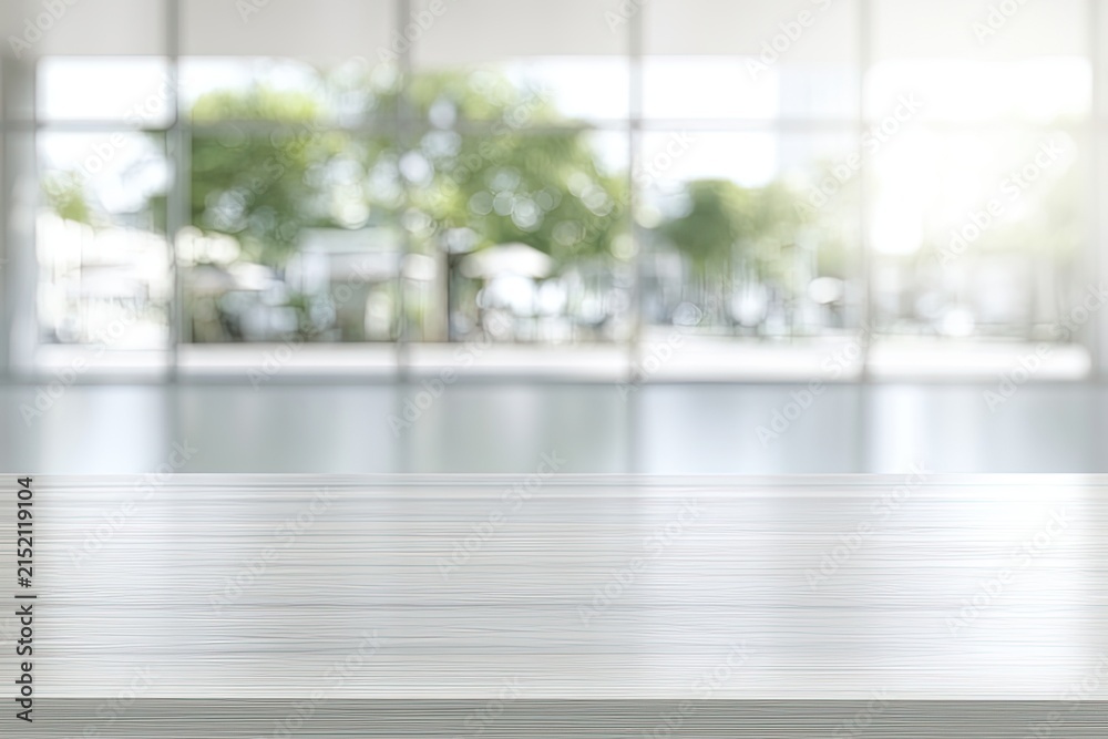 Fototapeta premium Bright, empty modern space with a glossy wooden desk and blurred outdoor view