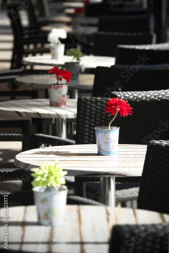 perspective of table decorated with colorful flowers in outdoor cafe 