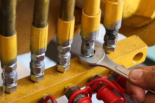 Quadro su tela Mechanic using a 14mm wrench on hydraulic manifold fittings.