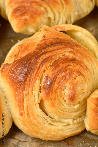 Принти на полотні A detailed close up view of a round freshly baked croissant showing the flaky golden brown layers of puff pastry