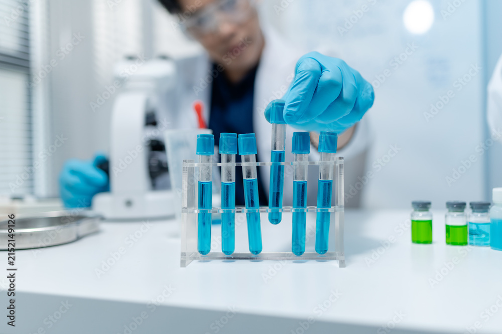 Fototapeta premium Scientists analyze liquid samples using test tubes, microscopes, and laboratory equipment, representing biotechnology, medical diagnostics, research, and healthcare innovation.