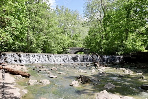 The waterfall in the woods on a sunny day.