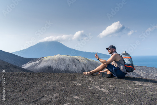 A young man exploring the volcanic structure of Mount Krakatoa Volcano  in Indonesia.