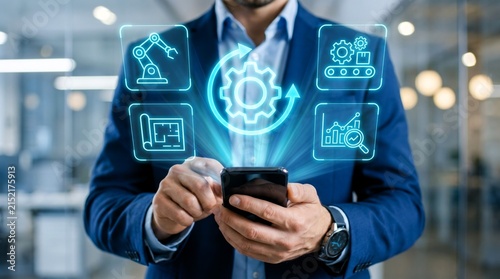 Professional businessman in blue suit interacts with glowing digital manufacturing icons projected from a smartphone screen for industrial data analytics
