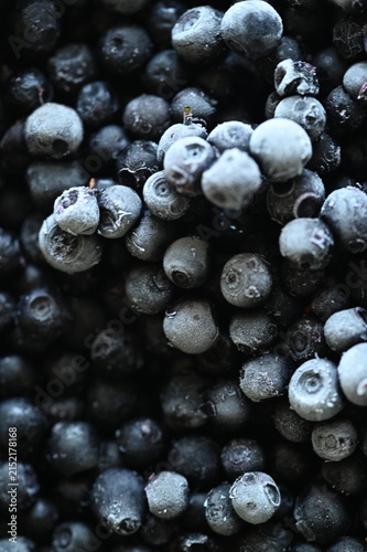 Close-up macro view of frozen wild blueberries prepared as a cooking ingredient, with other fresh ingredients in the background.