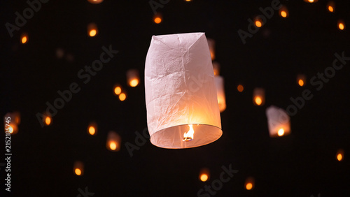 Sky lantern floating in the dark night sky, Tourist floating sky lanterns, Sky lanterns floating on night of Yi Peng, Loy Krathong Festival or Yi Peng Festival in Chiang Mai Thailand.