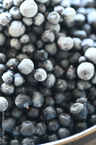 Photography Close-up macro view of frozen wild blueberries prepared as a cooking ingredient, with other fresh ingredients in the background