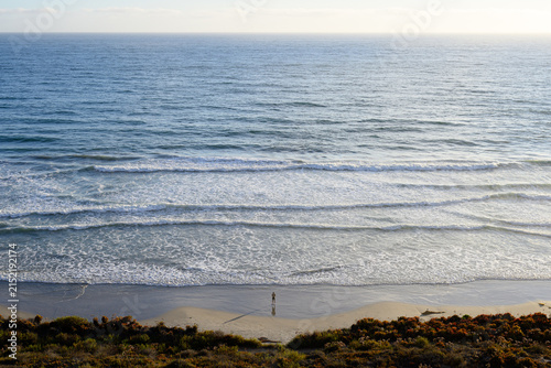 Obraz na plátne Single fisherman alone at the beach shore with endless peaceful meditative ocean