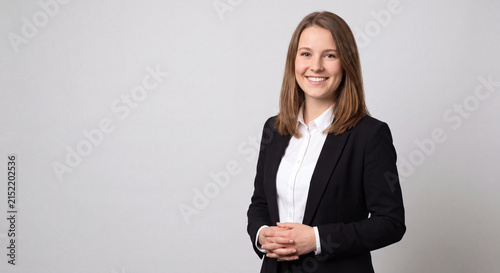 Portrait of a young smiling businesswoman in a black suit
