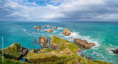 Blick vom Nugget Point Lighthouse auf die Felsstapel The Nuggets im türkisfarbenen Meer, Otago, Neuseeland