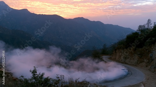 Breathtaking mountain road shrouded in mist during sunset showcasing the beauty of nature and tranquil landscapes