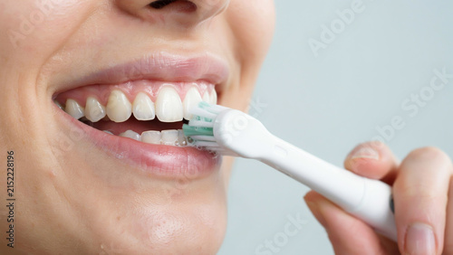 Woman using interdental brush to clean teeth, close-up, dental hygiene oral care desi