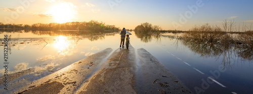 Sunset casts golden light over flooded rural road